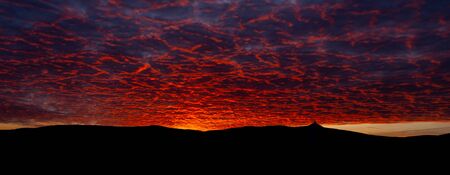 Silhouette of Jested mountain at sunset time with beautyifully illuminated evening sky, Liberec, Czech Republic.の写真素材