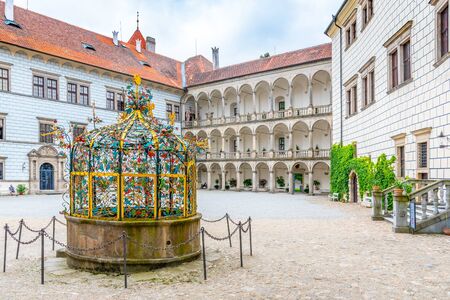 JINDRICHUV HRADEC, CZECH REPUBLIC - 27 JULY, 2019: Great arcades - white renaissance archs on Third Courtyard with ornamental well. Jindrichuv Hradec Castle in Jindrichuv Hradec, Czech Republic.のeditorial素材