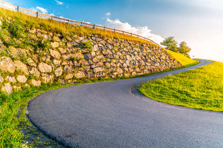 Sharp hairpin curve of narrow rural asphalt road in the mountains. Austrian Alps, Austria.の写真素材