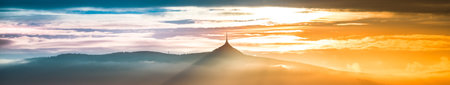 Panorama of Jested mountain ridge with silhouette of unique mountain hotel and TV transmitter. Moody...