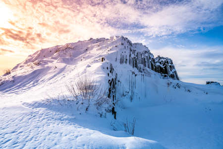 Panska skala - rock formation of pentagonal and hexagonal basalt columns. Looks like giant organ pipes. Covered by snow and ice in winter time. Kamenicky Senov, Czech Republic.の写真素材