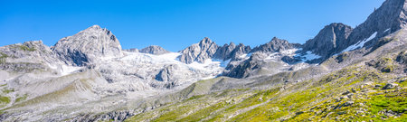 Alpine peaks with melting glacier on sunny summer day