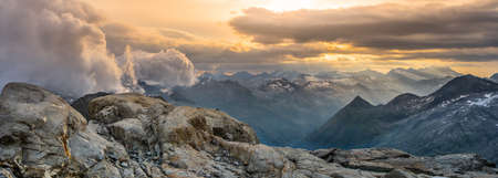 Rocky alpine mountains morning panorama. Cloudy sunrise on summer day. Grossglockner Mountain, Hohe Tauern National Park, Austrian Alpsの写真素材