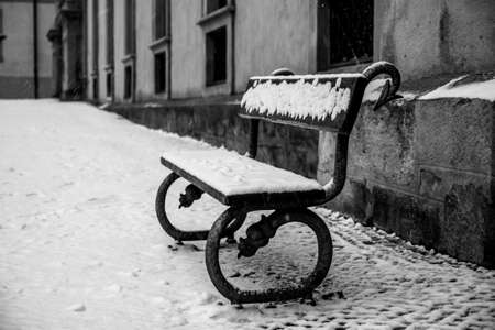 Abandoned street bench covered by snowの写真素材