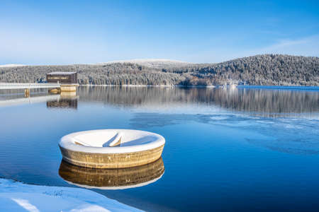 Winter scenery with mountain forests and water reservoirの写真素材