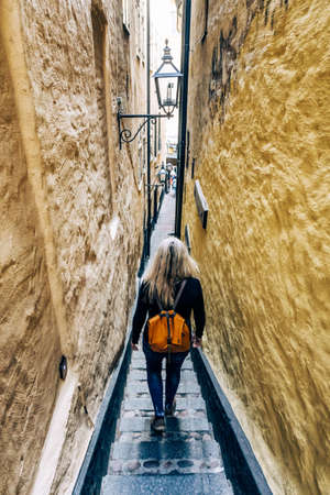 Woman in the narrowest street of Stockholmの写真素材