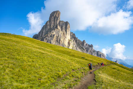 Group of hikers walks towards mountainsの写真素材