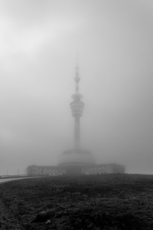The broadcasting and observation tower on Praded Mountain shrouded in clouds. Hruby Jesenik, Czech Republic. Black and white image.の写真素材