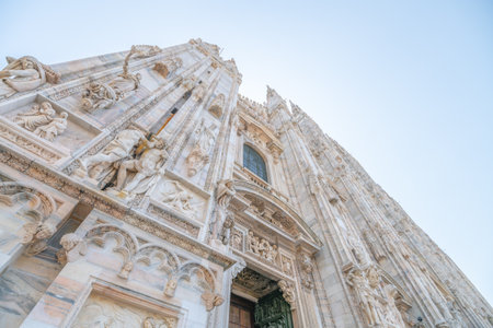 Milan Cathedral, Italian: Duomo di Milano, or Metropolitan Cathedral-Basilica of the Nativity of Saint Mary. View of main door and white marble facade on sunny summer day. Milan, Lombardy, Italyの写真素材