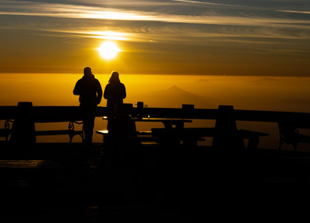 Romantic silhouette of couple at sunset time on sunny cold evening. Jested mountain, Liberec, Czech...