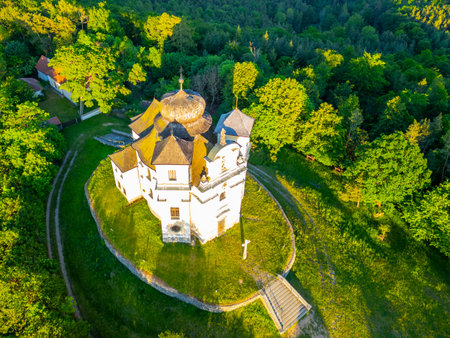 Aerial view of the Church of Saint John the Baptist and Our Lady of Mount Carmel surrounded by lush greenery at Makova Hora, Czechia, on a bright spring day.の写真素材