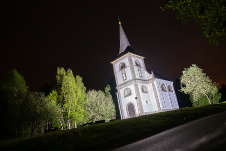 The Church of Saint John of Nepomuk stands majestically on Zvicina Hill, illuminated against the night sky, surrounded by greenery and tranquility. A serene and picturesque sight in Czechia.の写真素材