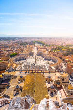 Visitors gather in St. Peters Square, enjoying the warm sunlight and stunning architecture of St. Peters Basilica, while the peaceful atmosphere surrounds this iconic location.の写真素材