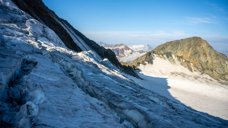 The Taschachferner Glacier in the Otztal Alps, Austria, showcases stunning icy formations and rugged mountain landscapes under a clear blue sky, inviting adventurers to explore its breathtaking beauty.の写真素材