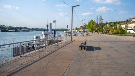 People enjoy a leisurely walk on the Sava Promenade, with the river and waterfront scenery creating a peaceful atmosphere in Belgrade, Serbia.の写真素材
