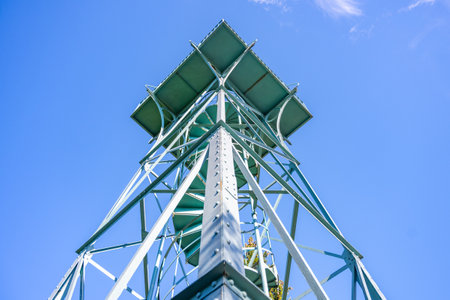 The Slovanka Iron Lookout Tower rises against a clear blue sky in the Jizera Mountains, providing panoramic views of the surrounding landscape and inviting visitors to explore.の写真素材