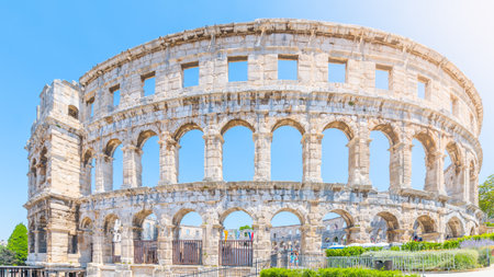 The Roman amphitheatre in Pula, located on the Istria Peninsula, stands as a remarkable symbol of ancient engineering. Visitors explore its impressive arches and stone walls.の写真素材