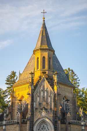 The Schwarzenberg Tomb stands majestically in Domanin near Trebon, Czechia, showcasing intricate architecture bathed in warm light under a clear sky, surrounded by lush greenery.の写真素材