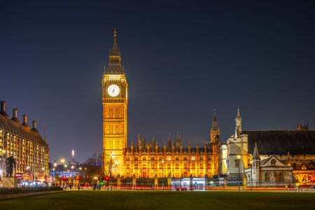 Big Ben stands tall against the night sky, glowing with golden light. The historic clock tower, part of the Houses of Parliament, attracts visitors in the heart of London.の写真素材