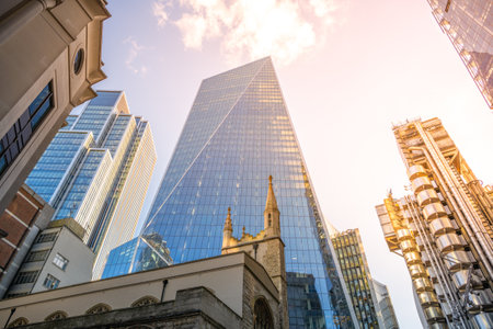 St Andrew Undershaft Church stands in front of towering modern skyscrapers in the heart of Londons financial district, showcasing the blend of history and contemporary architecture.の写真素材