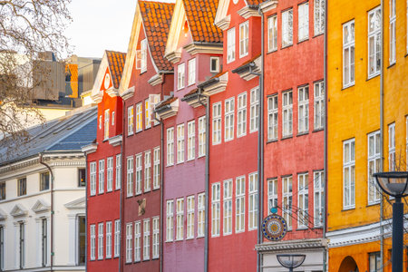 Brightly painted houses line the streets of Copenhagen, showcasing vibrant hues of red and yellow....