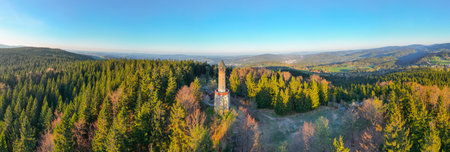 Stepanka Lookout Tower stands tall amidst vibrant spring greenery in Korenov. Early morning light illuminates the surrounding Jizera Mountains, creating a serene atmosphere perfect for nature lovers.の写真素材