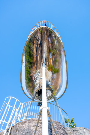 Visitors enjoy breathtaking views from the Sipka lookout platform in the Jizera Mountains, Czechia, surrounded by lush greenery and a clear blue sky on a sunny day.の写真素材