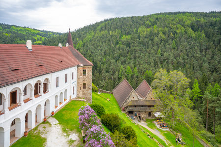 Nestled in a lush green landscape, Velhartice Castle features classic Renaissance design with white...