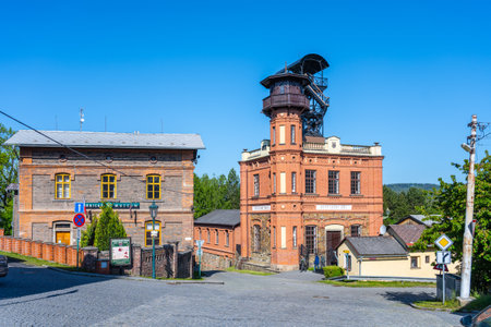 Historic structures of Sevcinsky mine in Brezove hory showcase Czechias mining heritage. Bright sky illuminates the vibrant brickwork, with well-maintained landscaping enhancing the site.の写真素材