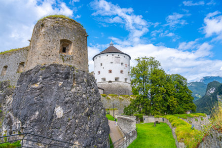 Visitors admire the historic Kufstein Fortress located in the scenic Tyrol region of Austria, surrounded by lush greenery and dramatic mountain views on a beautiful day.の写真素材