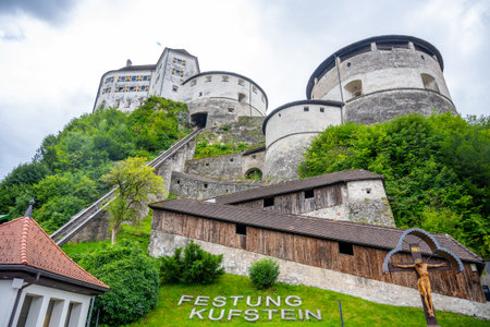 Kufstein Fortress stands majestically in Tyrol, Austria, surrounded by lush greenery. Visitors can explore its old architecture and enjoy stunning views of the surrounding mountains.の写真素材