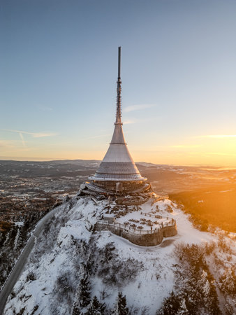 Jested Mountain showcases a stunning winter landscape illuminated by the soft light of sunrise. Snow blankets the peaks, creating a serene and tranquil atmosphere.の写真素材