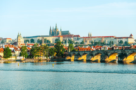 Discover the stunning architecture of Prague Castle overlooking the Vltava River and the iconic Charles Bridge. This clear day showcases the citys historical charm and landscape beauty.の写真素材