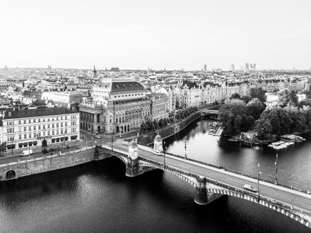 The iconic National Theatre stands by the Vltava River, showcasing stunning architecture. Aerial perspective highlights the charm of Prague, blending history and urban life seamlessly.の写真素材