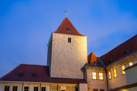 The Black Tower of Prague Castle stands majestically under the night sky, illuminated by warm street lamps. Its historical architecture offers a glimpse into Pragues rich heritage and beauty.の写真素材