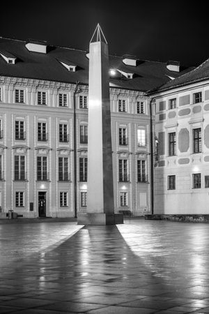 The Mrakotin Monolith stands tall in the courtyard of Prague Castle, beautifully illuminated by street lamps.の写真素材