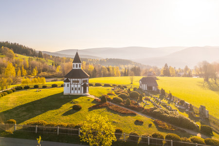 Tesarov Chapel stands proudly in Korenov, surrounded by lush greenery and distant mountains. This octagonal structure is beautifully lit by the evening sun, offering serene views of the landscape.の写真素材