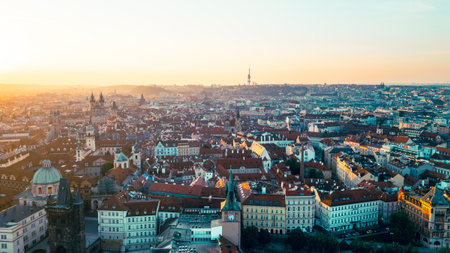 A beautiful aerial view captures the Old Town of Prague bathed in warm morning light. The charming roofs, historic buildings, and the Vltava River create a stunning panorama.の写真素材
