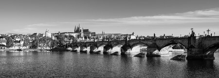This captivating view showcases the grandeur of Prague Castle alongside the iconic Charles Bridge. The Vltava River reflects the historic architecture, creating a serene atmosphere.の写真素材
