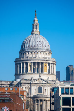 The majestic dome of St. Pauls Cathedral rises against a vibrant blue sky, showcasing its architectural grandeur in the heart of London. It stands as a symbol of historical significance.の写真素材