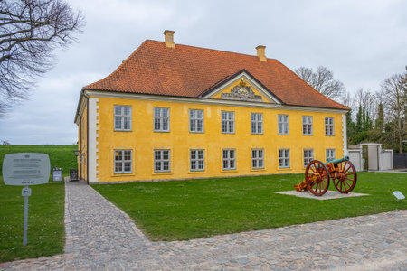 Located in Copenhagen, the Commanders House of Kastellet features a distinctive yellow facade and historical cannon. The site offers insight into Denmarks military past amidst scenic surroundings.の写真素材