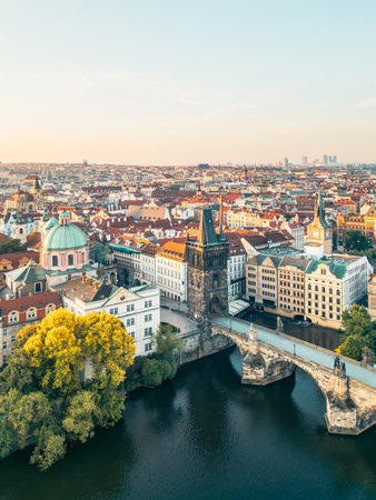 Stunning aerial view captures Charles Bridge and the Old Town Bridge Tower at sunrise, surrounded by the beautiful architecture of Prague along the Vltava River.の写真素材