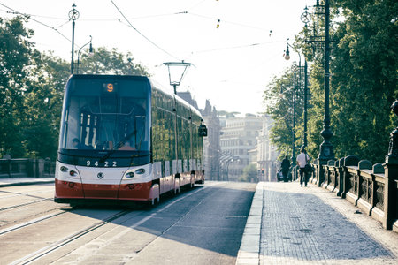A modern tram glides over Legion Bridge in Prague, serving commuters and tourists during early morning hours. The historical architecture forms a stunning backdrop in this vibrant city.の写真素材