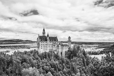 Neuschwanstein Castle rises majestically amid lush forests and rolling hills. This iconic fairytale chateau captures the imagination with its stunning architecture and historical charm.の写真素材