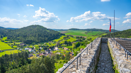 Visitors enjoy a panoramic view from the Donjon Tower of Rabi Castle in Czechia. The lush green landscape stretches across the horizon, showcasing rolling hills and quaint villages below.の写真素材