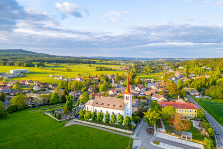 Above the town of Bohutin, the Church of Saint Mary Magdalene stands out among lush green fields and...