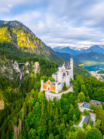 Neuschwanstein Castle, nestled in the Bavarian Alps, captivates with its fairytale architecture surrounded by lush greenery and majestic mountains, inviting visitors to experience its dreamlike charm.の写真素材