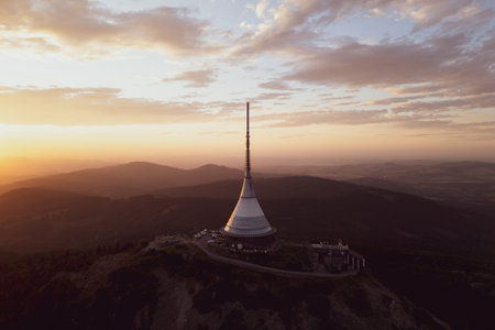 Jested Mountain showcases modern architecture under a vibrant sunset. Perched atop the mountain, it...
