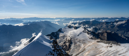 Hikers navigate the sharp, steep ridge of Piz Palu, enjoying stunning views of the surrounding Alps...