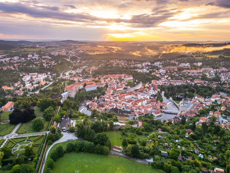 The sunrise casts golden hues over Cesky Krumlov, illuminating the historic town and its castle. Nestled along the Vltava River, the citys stunning architecture reflects a rich heritage.の写真素材